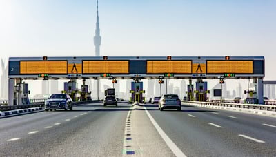 Modern road toll system in Dubai with cars passing through electronic gates